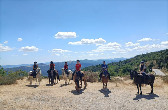 groupe d’ados à cheval devant un panorama en Ardèche