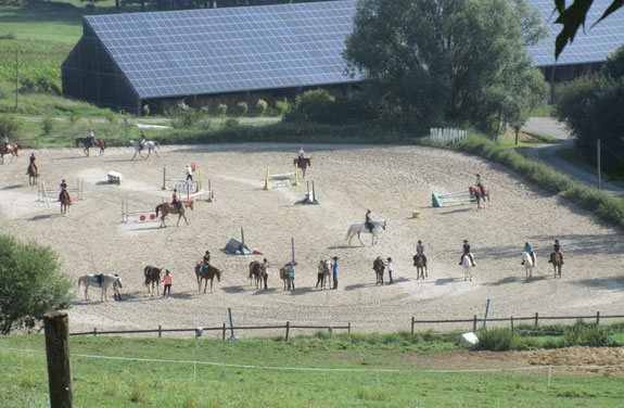 Groupe de cavaliers évoluant dans la carrière lors de la colonie équitation