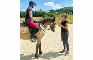 Monitrice donnant des conseils à une adolescente lors de la colonie équitation en Tarn-et-Garonne
